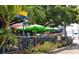 Outdoor seating area featuring umbrellas, palm trees, and landscaping at 6610 Midnight Pass Rd # 11, Sarasota, FL 34242
