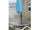 Outdoor patio featuring a round glass table, seating, and a blue umbrella for shaded relaxation at 6610 Midnight Pass Rd # 11, Sarasota, FL 34242