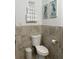 Bathroom featuring a modern toilet, towel storage, and decorative coastal themed art at 6610 Midnight Pass Rd # 11, Sarasota, FL 34242