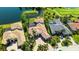 Aerial shot of a luxurious home with a pool, backing onto a golf course and a serene lake at 6819 Dominion Ln, Lakewood Ranch, FL 34202