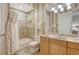 Well-lit bathroom showcasing neutral tile, vanity with sink and a shower/tub with decorative curtains at 6819 Dominion Ln, Lakewood Ranch, FL 34202