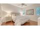 Bright bedroom features wood floors, a ceiling fan, and soft, neutral decor with plantation shutters on the windows at 6819 Dominion Ln, Lakewood Ranch, FL 34202