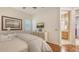Cozy bedroom showcasing warm wood floors, television, and view to the ensuite bathroom at 6819 Dominion Ln, Lakewood Ranch, FL 34202