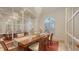Elegant dining room with a large wooden table, chandelier, and mirrored wall at 6819 Dominion Ln, Lakewood Ranch, FL 34202