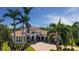 Elegant Mediterranean-style home featuring a tile roof, lush landscaping, and a circular driveway at 6819 Dominion Ln, Lakewood Ranch, FL 34202