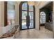 Grand foyer with double doors, chandelier, neutral tiles, and view of front yard at 6819 Dominion Ln, Lakewood Ranch, FL 34202