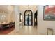 Beautiful foyer with travertine floors and chandelier, transitioning to dining room at 6819 Dominion Ln, Lakewood Ranch, FL 34202