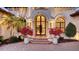 Elegant front entrance with arched doorway, lush landscaping, and beautiful planters at 6819 Dominion Ln, Lakewood Ranch, FL 34202