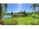 Scenic golf course view with a pristine pond and lush green landscaping under a bright blue sky at 6819 Dominion Ln, Lakewood Ranch, FL 34202