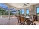 Outdoor dining area showcasing a brick floor and fireplace, grill, and beautiful backyard at 6819 Dominion Ln, Lakewood Ranch, FL 34202