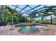 Inviting in-ground pool with an attached spa, surrounded by a screened enclosure and lush greenery at 6819 Dominion Ln, Lakewood Ranch, FL 34202