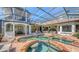Stunning screened-in pool and spa with brick accents and a spacious outdoor seating area, perfect for relaxation at 6819 Dominion Ln, Lakewood Ranch, FL 34202
