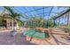 Screened-in pool area featuring mature palm trees and manicured landscaping at 6819 Dominion Ln, Lakewood Ranch, FL 34202