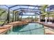 Inviting screened-in pool and spa with golf course views, adjacent to outdoor dining and lounge areas at 6819 Dominion Ln, Lakewood Ranch, FL 34202