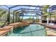 Inviting screened-in pool and spa with golf course views, adjacent to outdoor dining and lounge areas at 6819 Dominion Ln, Lakewood Ranch, FL 34202