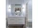 White bathroom with modern floating double vanity and a shower with striped curtain at 7141 37Th N Ave, St Petersburg, FL 33710