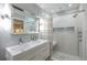 Bright bathroom featuring double vanity, shower with seat, and hexagon backsplash at 7141 37Th N Ave, St Petersburg, FL 33710