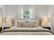 Bright bedroom with white walls, windows, and soft light, features an upholstered headboard and stylish pillows at 7141 37Th N Ave, St Petersburg, FL 33710