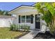Welcoming front entry featuring a decorative door and a bench surrounded by meticulously maintained landscaping at 7141 37Th N Ave, St Petersburg, FL 33710