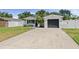 Charming home featuring a dark grey garage door, a well-manicured lawn, and a white picket fence at 7141 37Th N Ave, St Petersburg, FL 33710