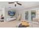 Bright living room featuring a media wall, ceiling fan, and glass doors that lead to the outdoors at 7141 37Th N Ave, St Petersburg, FL 33710