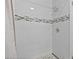 The shower features white tile, mosaic tile accents, and pebble flooring for a clean, modern look at 7141 37Th N Ave, St Petersburg, FL 33710