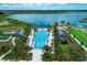 Aerial view of a luxurious pool area with resort-style amenities and scenic lake views at 749 Tailwind Pl, Sarasota, FL 34240