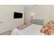 Bright bedroom featuring a TV, dresser, and bed with floral bedding accents and a white quilted comforter at 749 Tailwind Pl, Sarasota, FL 34240