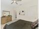 Bedroom with a ceiling fan, neutral decor, and a natural wood dresser accented with a mirror and greenery at 749 Tailwind Pl, Sarasota, FL 34240