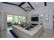 Bright living room with vaulted ceilings, modern lighting, fireplace, and sliding glass doors to the outdoor living space at 749 Tailwind Pl, Sarasota, FL 34240