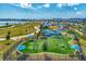Community playground featuring colorful play structures, a soft surface, and covered benches on a sunny day at 749 Tailwind Pl, Sarasota, FL 34240