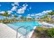 Large community swimming pool with ample seating and lush tropical landscaping on a bright day at 749 Tailwind Pl, Sarasota, FL 34240