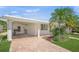 Home with white tile roof, manicured landscaping, and a covered parking area at 773 Spanish N Dr, Longboat Key, FL 34228