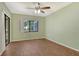 Spacious bedroom with wood-look flooring and a large window overlooking the serene landscape at 7876 Eagle Creek Dr, Sarasota, FL 34243
