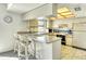 An eat-in kitchen features tile flooring, white appliances, and counter seating at 7876 Eagle Creek Dr, Sarasota, FL 34243