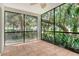 Enclosed lanai with tile floors and a view of lush greenery provides a relaxing outdoor living space at 7876 Eagle Creek Dr, Sarasota, FL 34243