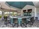 Stylish clubhouse bar with ample seating, mounted TVs, and views of pool and palm trees at 7889 Mainsail Ln, Sarasota, FL 34240