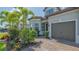 Beautiful home showcasing a lush garden, stately entryway and a convenient two-car garage at 7889 Mainsail Ln, Sarasota, FL 34240