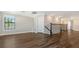 Wide hallway with wood floors, staircase with iron railings, and natural light from window at 7889 Mainsail Ln, Sarasota, FL 34240
