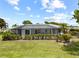 Spacious backyard with a screened pool enclosure, lush greenery, and a well-kept lawn, perfect for outdoor activities at 7912 Estates Dr, Sarasota, FL 34243