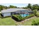 Aerial shot of a beautiful home with a screened pool, surrounded by lush landscaping and a well-manicured lawn at 7912 Estates Dr, Sarasota, FL 34243