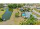 Beautiful aerial view of home with pool and adjacent pond, surrounded by lush greenery at 7912 Estates Dr, Sarasota, FL 34243
