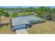 Gorgeous aerial view of a white home with mature landscaping and serene pond view at 7912 Estates Dr, Sarasota, FL 34243