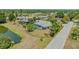 Aerial view of a home with screened pool, nearby pond, and landscaping at 7912 Estates Dr, Sarasota, FL 34243