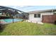 Picturesque backyard featuring a screened pool area, green lawn, and a paved patio for outdoor enjoyment at 7912 Estates Dr, Sarasota, FL 34243