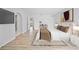 Comfortable bedroom with light wood floors, neutral tones, and an adjacent bathroom and walk-in closet at 7912 Estates Dr, Sarasota, FL 34243