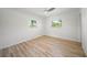 Clean bedroom with new flooring and multiple windows offering natural light and views of tropical landscaping at 7912 Estates Dr, Sarasota, FL 34243