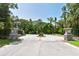 Welcoming entrance gate with stone pillars, landscaping, and a peaceful atmosphere at 7912 Estates Dr, Sarasota, FL 34243