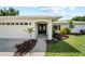 Charming home exterior showcasing a double door entry, well-kept lawn, and lovely landscaping at 7912 Estates Dr, Sarasota, FL 34243