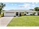 Charming single-story home boasts a well-manicured lawn, double-door entrance, and an attached two-car garage at 7912 Estates Dr, Sarasota, FL 34243